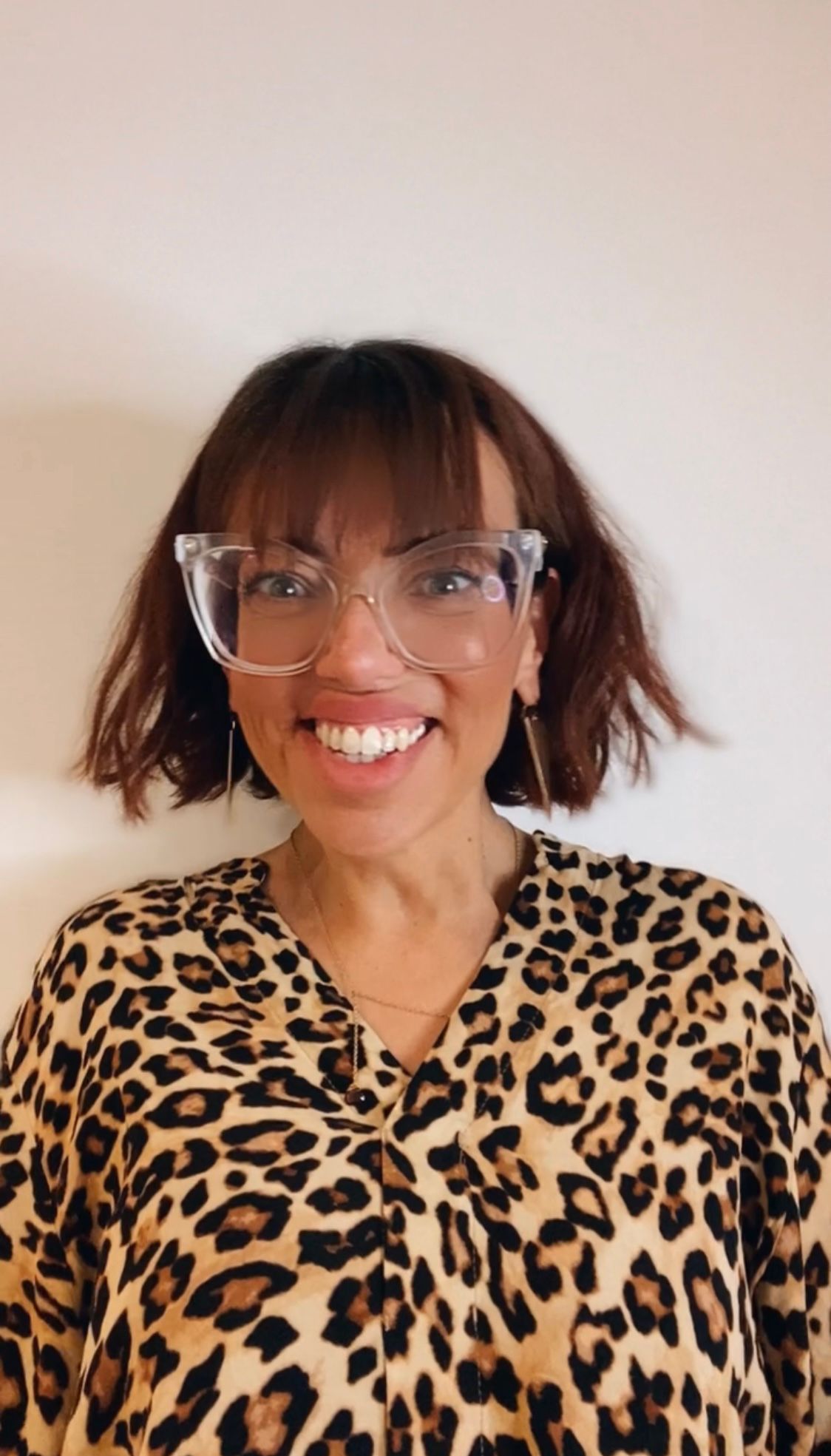 Foto de perfil de Ayleen Bown, usando oculos e sorrindo, usando uma camisa leopardo